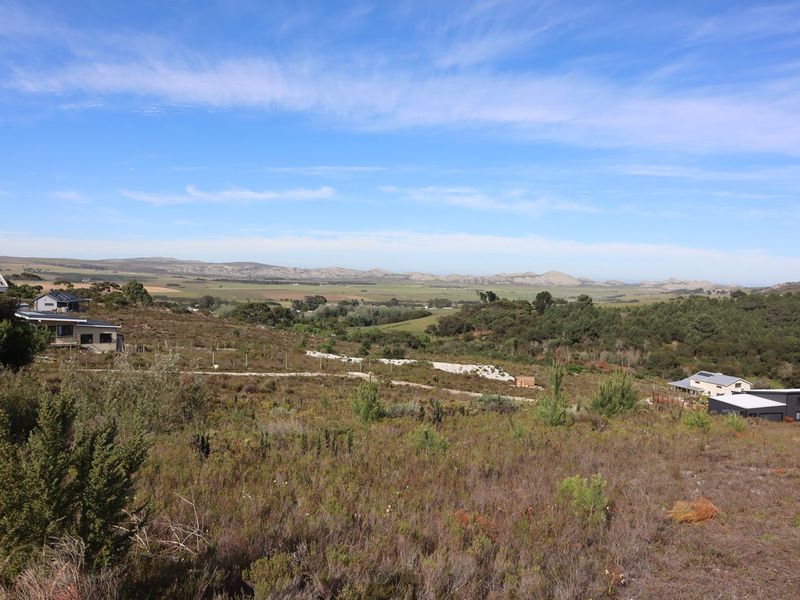 A scenic elevated view overlooking the expansive agricultural landscape, rolling hills, and distant mountain ranges.
