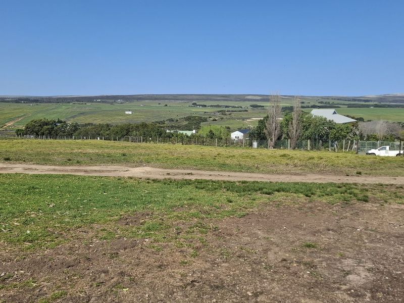 A wide-angle view of the vacant residential land, showcasing the surrounding rural landscape and open terrain.