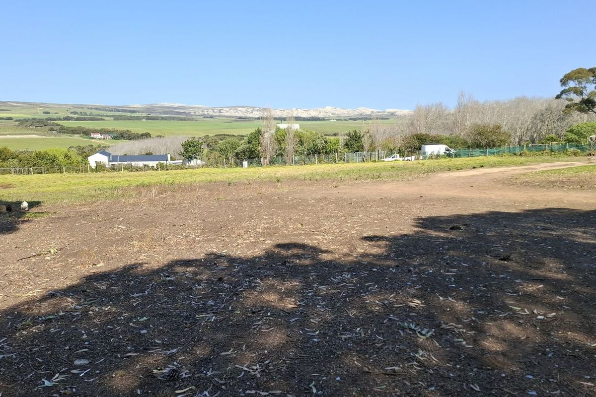 A wide-angle view of the vacant residential land, showcasing the surrounding landscape, natural vegetation, and distant hills.