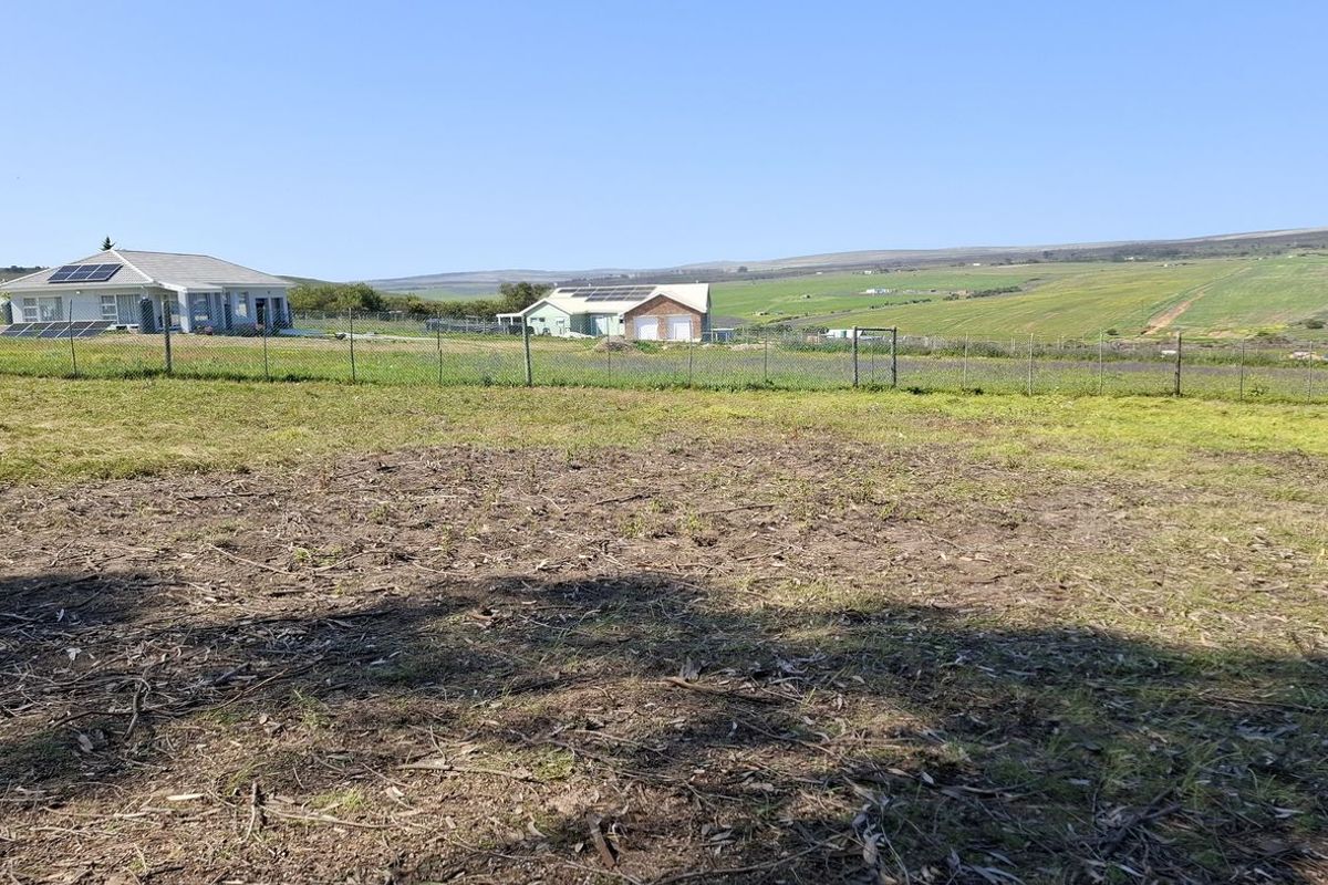 A view of a vacant residential plot featuring cleared land and perimeter wire mesh fencing, overlooking the surrounding rural landscape.