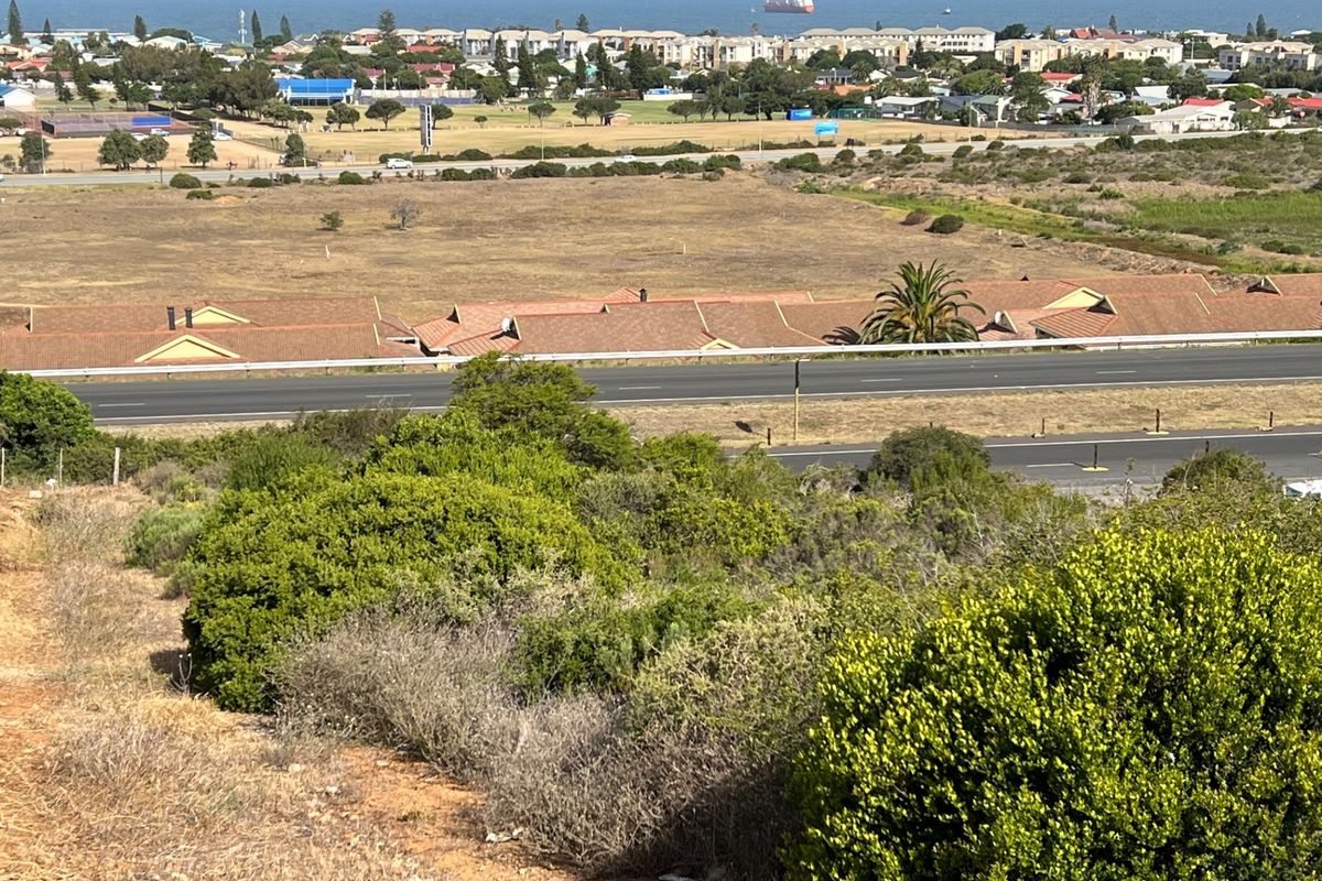 Elevated aerial view of the vacant residential land, showcasing the surrounding neighborhood, coastal landscape, and proximity to local infrastructure.