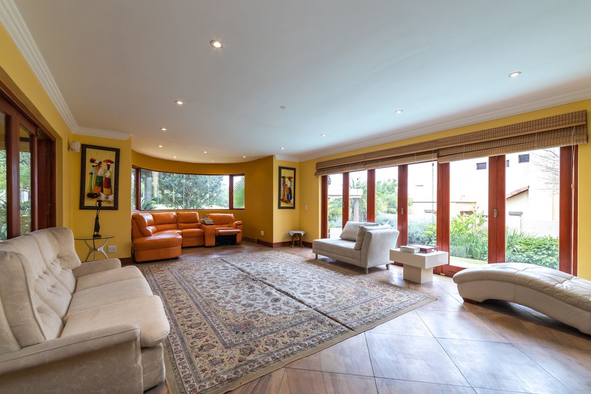 Spacious living room featuring large windows, recessed lighting, and timber-framed glass doors providing seamless access to the outdoor area.