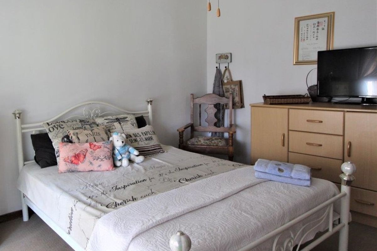 A functional bedroom featuring neutral wall finishes and carpeted flooring, providing a comfortable and straightforward living space.