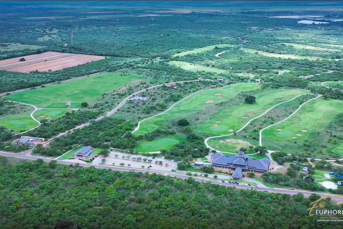 Aerial view of a residential golf estate featuring manicured fairways, green spaces, and established infrastructure within a natural landscape.