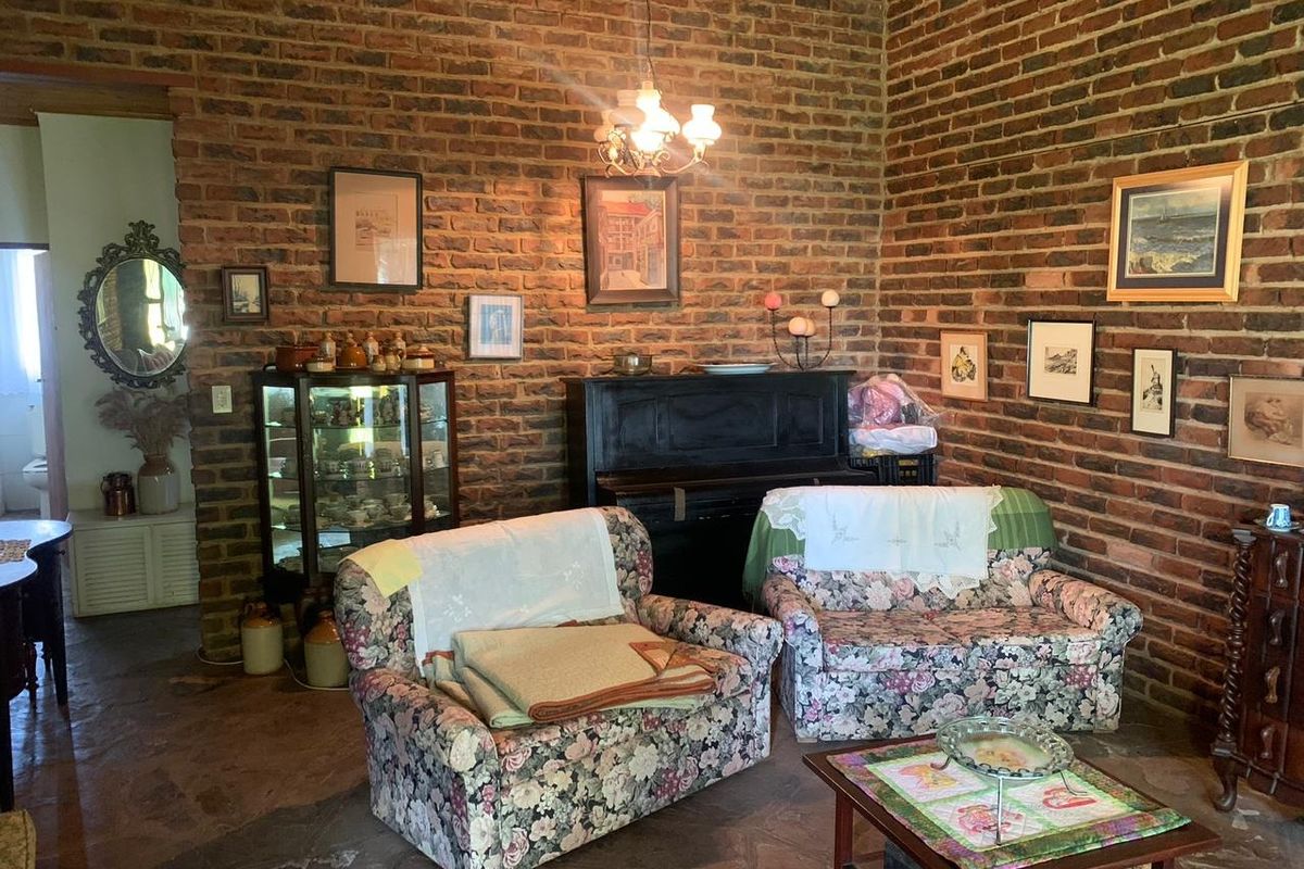 A rustic living room featuring exposed face-brick walls and traditional stone flooring, creating a warm and character-filled atmosphere.