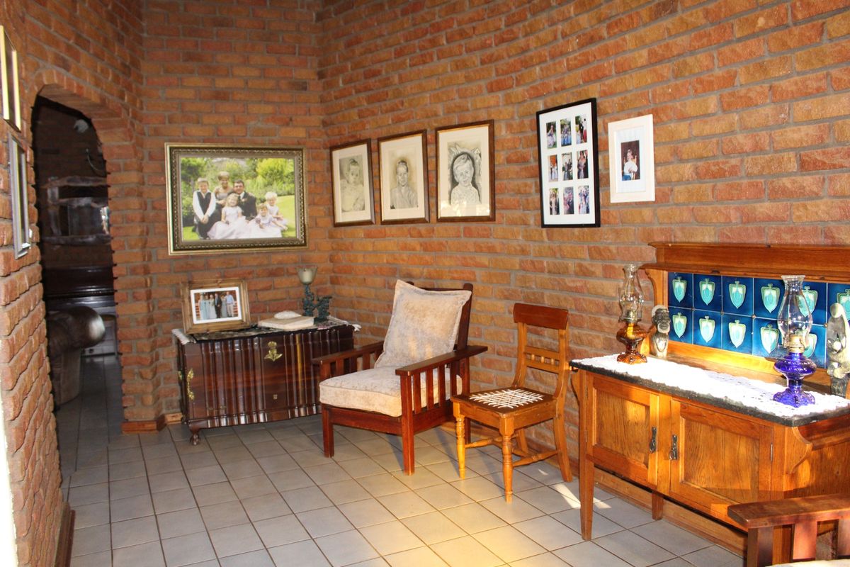 A rustic interior space featuring exposed face-brick walls, tiled flooring, and an arched doorway leading to an adjacent room.