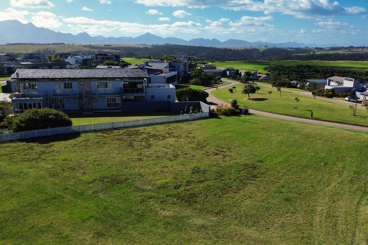Aerial view of the property showcasing the surrounding estate landscape, manicured lawns, and distant mountain vistas.
