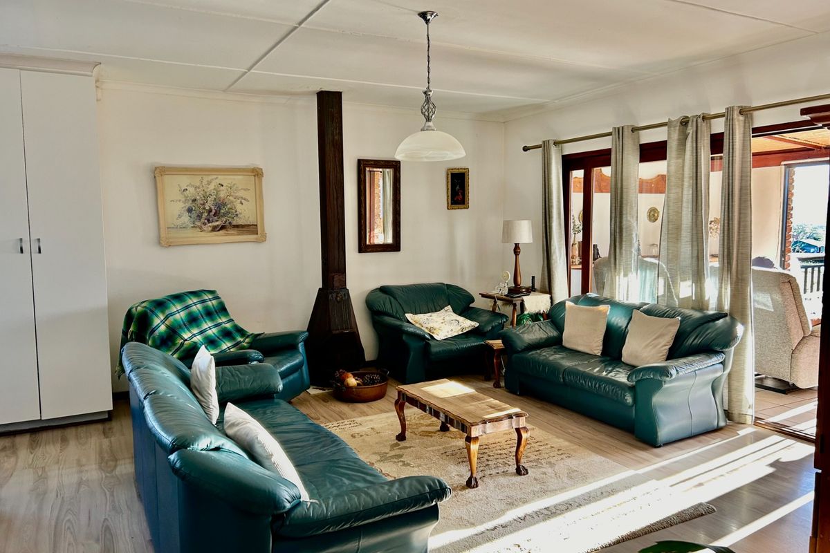 A comfortable living room featuring a built-in fireplace, laminate flooring, and large sliding doors providing access to an outdoor patio area.