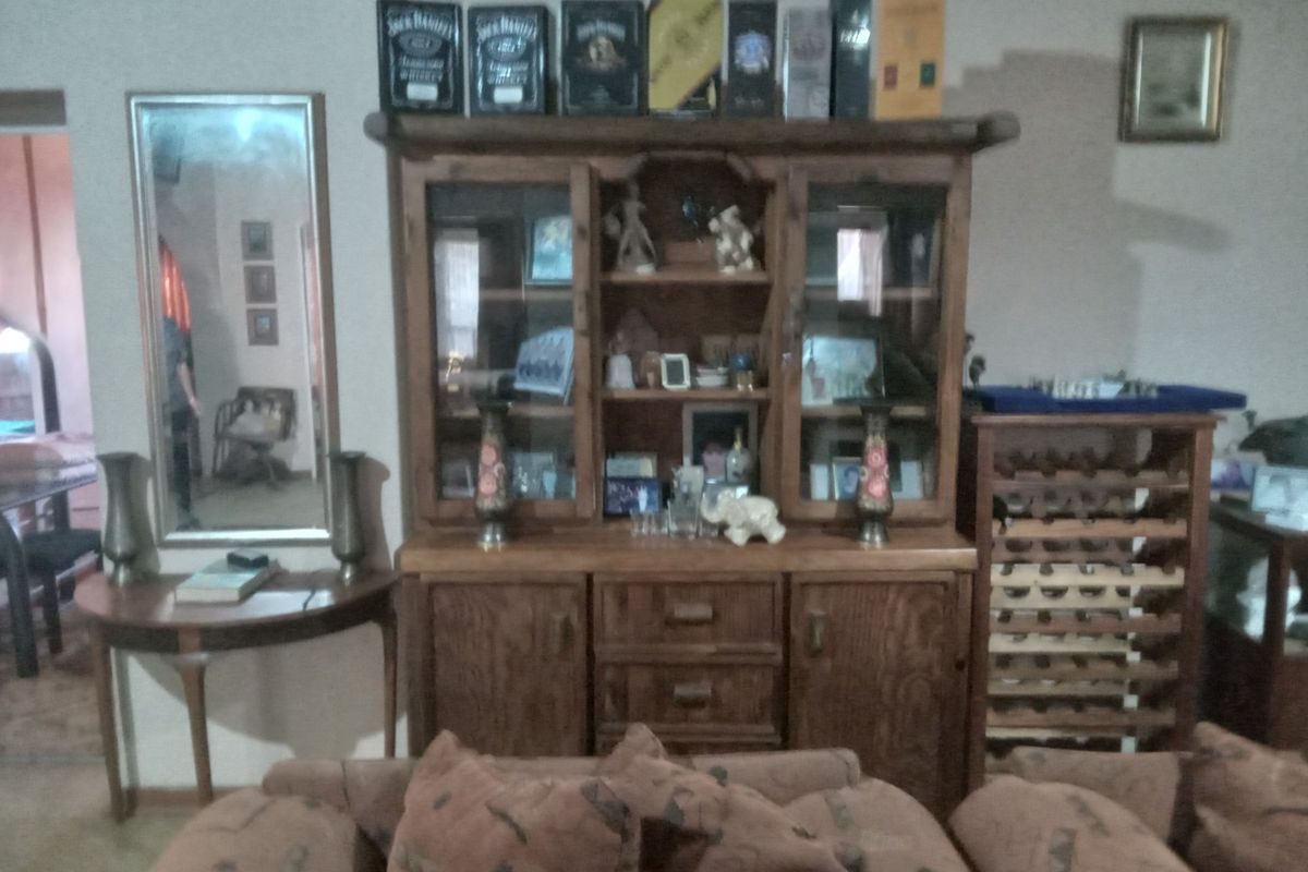 A view of a living area featuring a wooden display cabinet and a wine rack, showcasing the interior layout of the farm property.