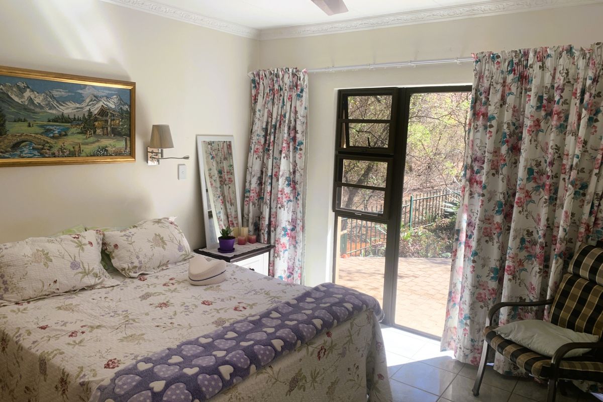 A bedroom featuring tiled flooring, decorative ceiling cornicing, a ceiling fan, and a glass door providing direct access to the outdoor patio area.