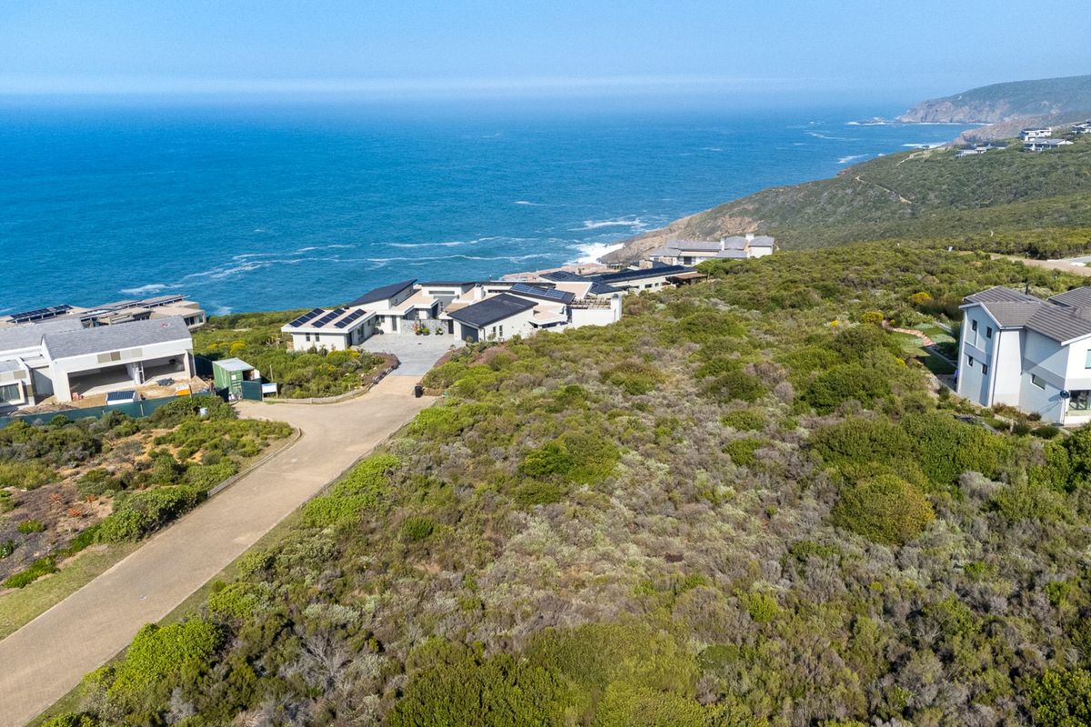 Aerial view of a coastal residential estate featuring vacant land plots and established modern homes with ocean views.