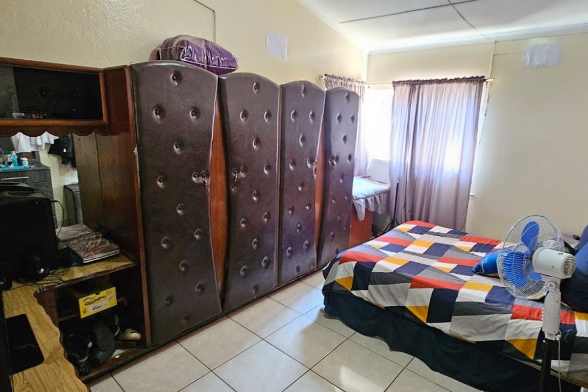 A bedroom featuring tiled flooring and built-in cabinetry, requiring cosmetic updates to improve the overall finish and aesthetic appeal.