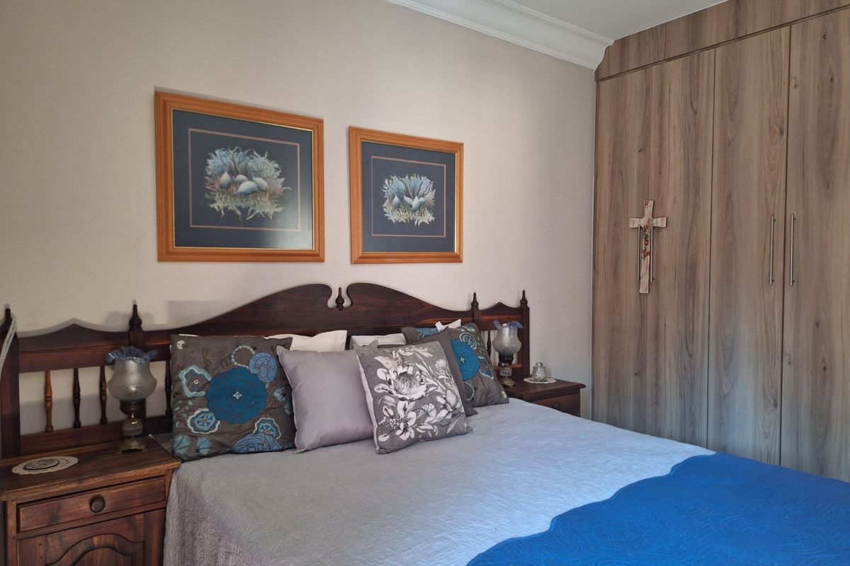 A well-maintained bedroom featuring built-in wooden cabinetry and crown molding, providing a clean and functional living space.