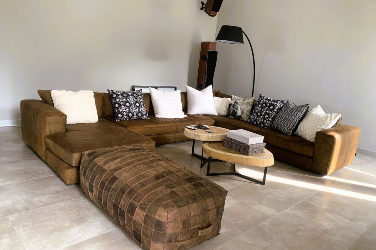 A spacious living room featuring large format floor tiles and neutral wall finishes, providing a clean and modern foundation for the living area.