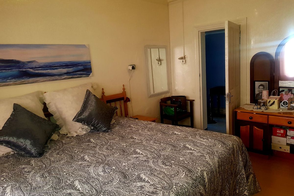 A bedroom featuring traditional architectural details, including high ceilings and a classic door frame, providing a functional and comfortable living space.