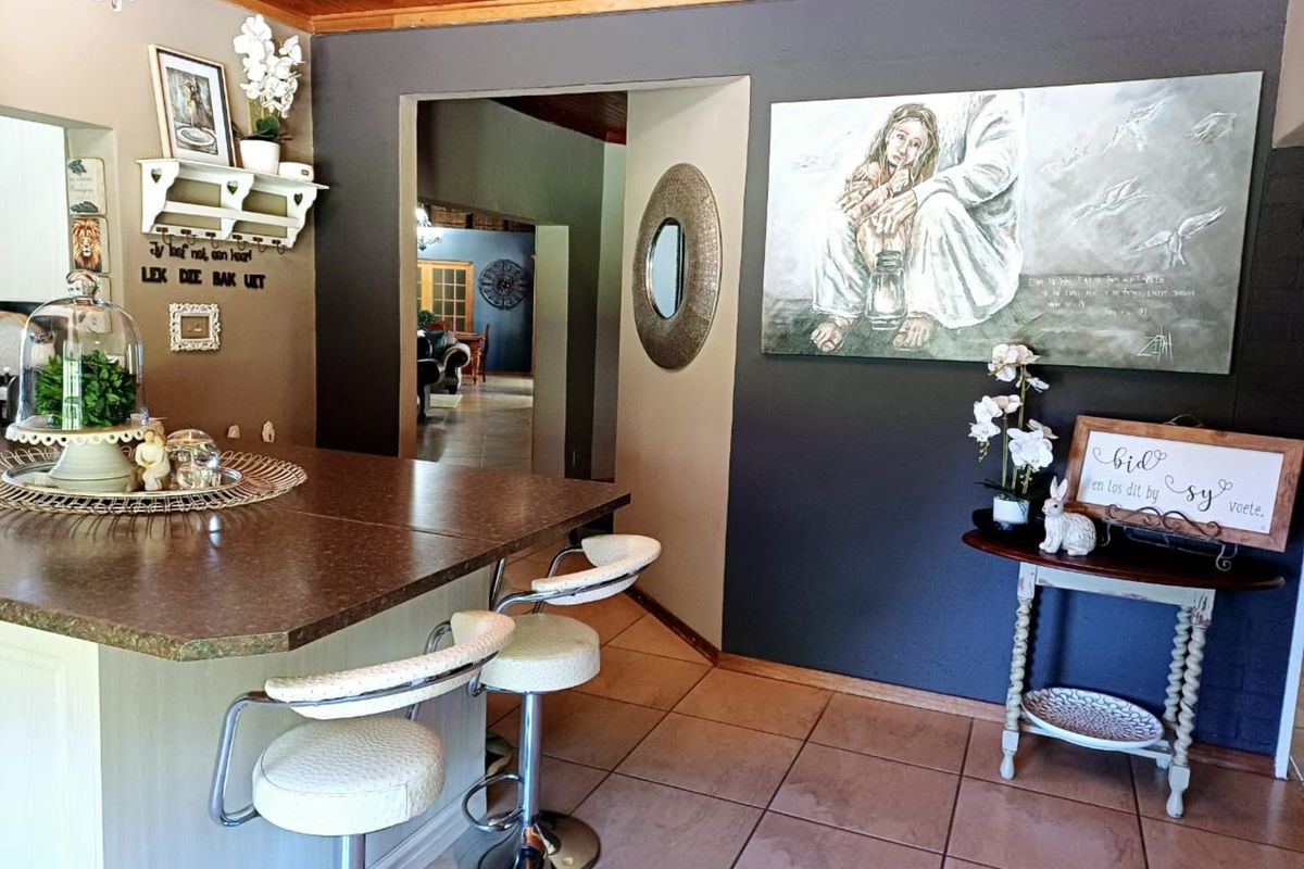 A view of the kitchen area featuring a breakfast bar with a stone-look countertop, tiled flooring, and a timber-paneled ceiling.