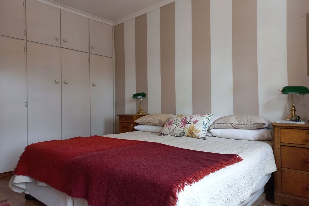A bedroom featuring built-in floor-to-ceiling cabinetry and striped wall finishes, providing functional storage space.