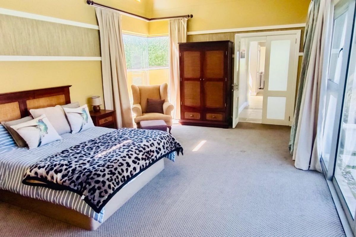 Spacious bedroom featuring neutral carpeting, large sliding glass doors providing natural light, and direct access to an outdoor area.