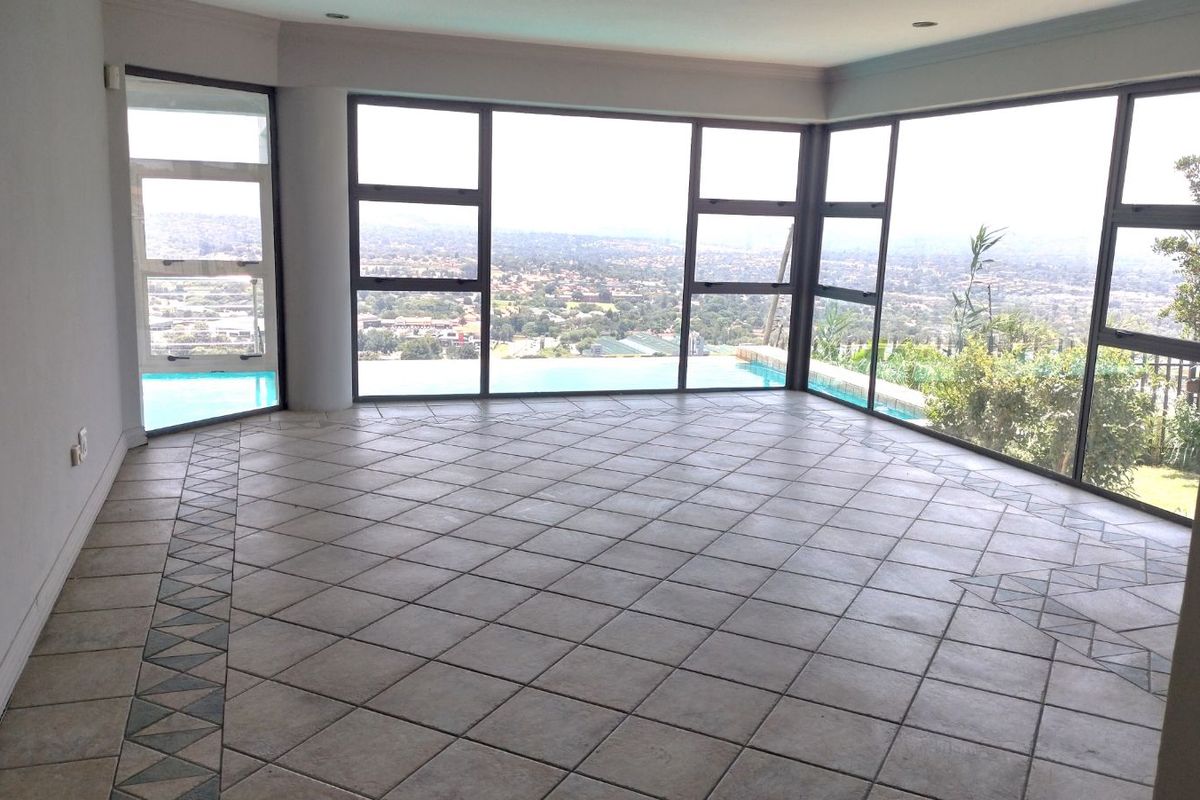 Spacious living area featuring large floor-to-ceiling windows with panoramic views and direct visual access to the outdoor pool area.