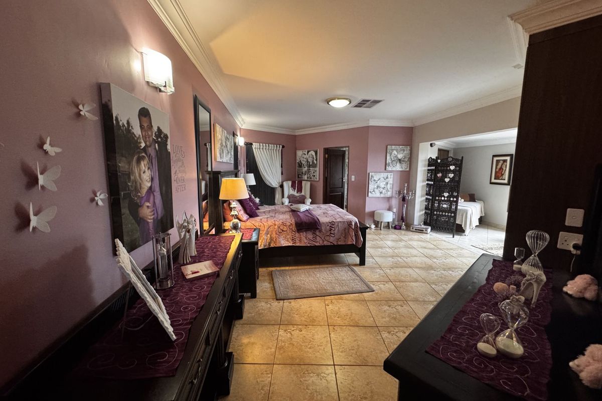 Spacious bedroom featuring tiled flooring, recessed ceiling lighting, and an adjoining secondary space, offering a versatile layout with neutral wall finishes.