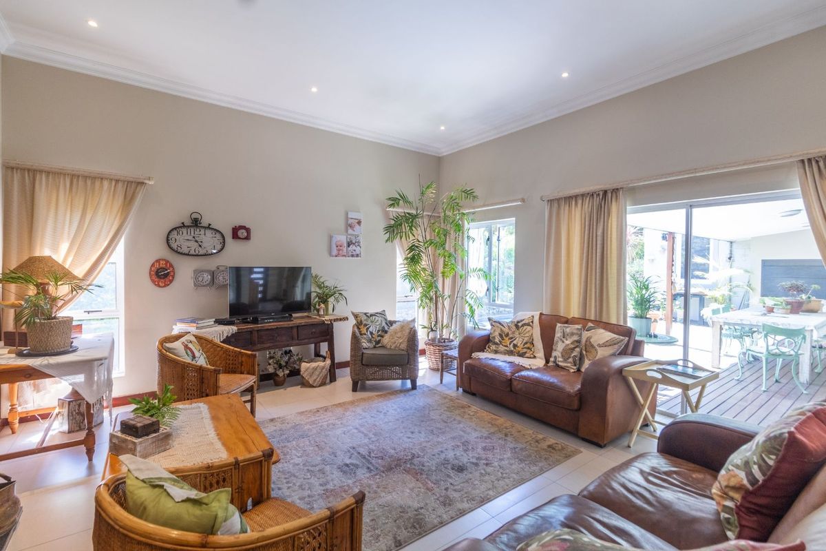 Spacious living room featuring tiled flooring, recessed downlighting, and large sliding glass doors providing seamless access to the outdoor patio area.