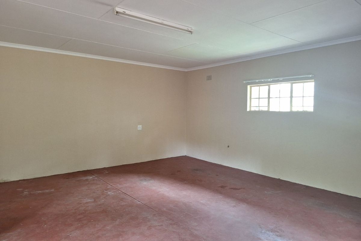An empty, versatile room featuring a painted concrete floor, neutral walls, and a standard window, suitable for various uses.