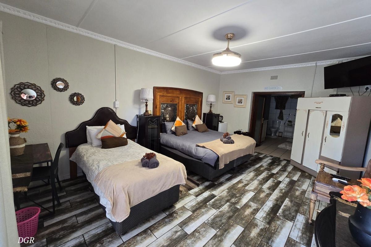 Spacious guest bedroom featuring tiled flooring, crown molding, and an en-suite bathroom access.