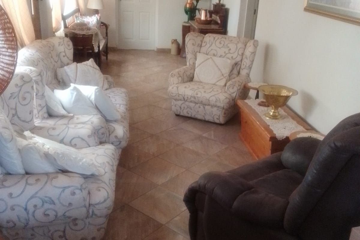 A living room featuring tiled flooring and neutral wall finishes, providing a functional and comfortable space for relaxation.