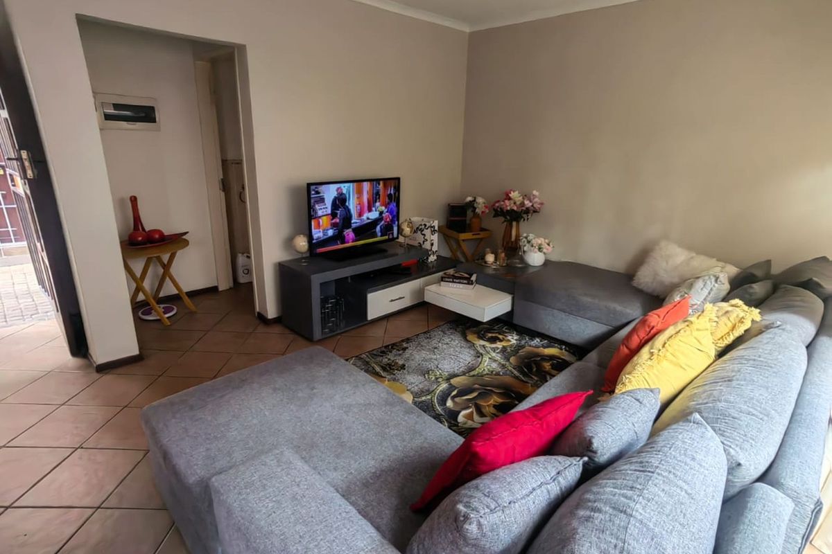 A living room area featuring tiled flooring and neutral wall finishes, providing a functional space for relaxation.
