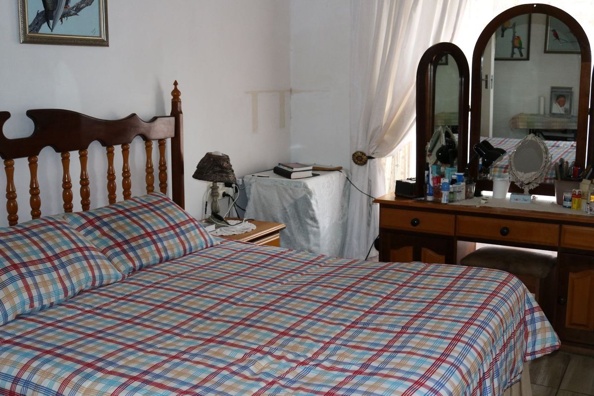 A bedroom featuring neutral walls and tiled flooring, providing a functional space for rest.