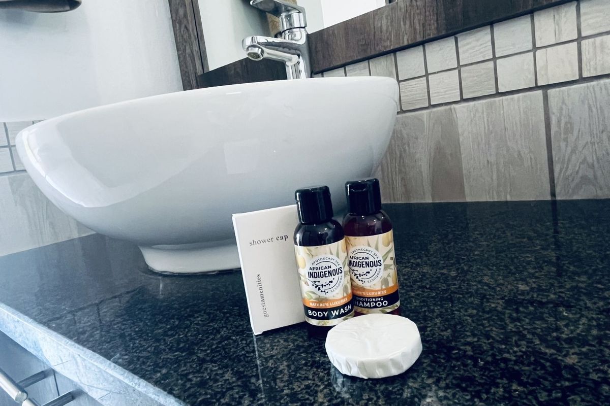 A close-up view of a bathroom vanity featuring a modern vessel sink, dark granite countertop, and tiled backsplash.