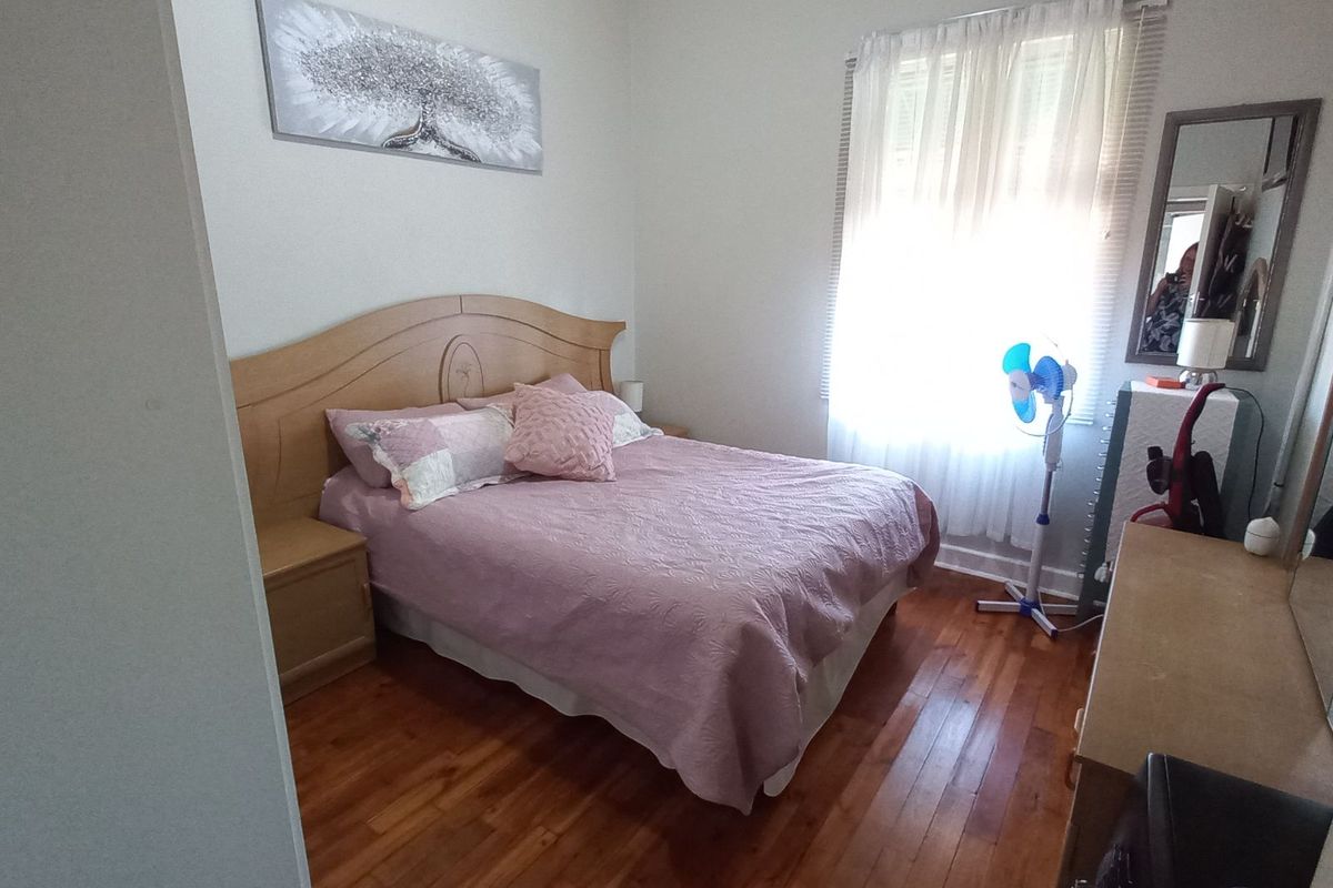 A bedroom featuring polished hardwood flooring and classic cove cornicing, offering a neutral base for interior design updates.