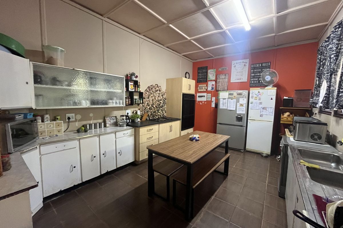 A functional kitchen featuring built-in cabinetry, a double sink, and integrated oven, offering a practical layout with potential for modernization.