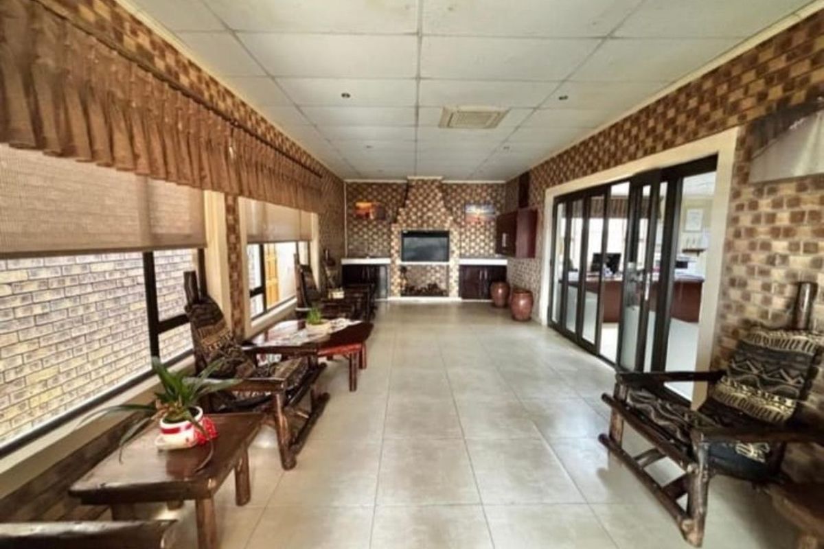 Spacious interior area featuring tiled flooring, built-in cabinetry, and large glass sliding doors providing natural light and access to adjacent office space.