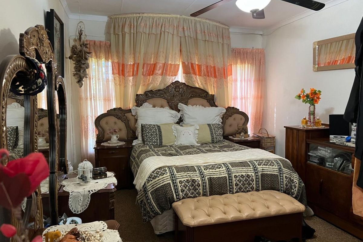 A bedroom featuring a ceiling fan and carpeted flooring, providing a functional space for rest.