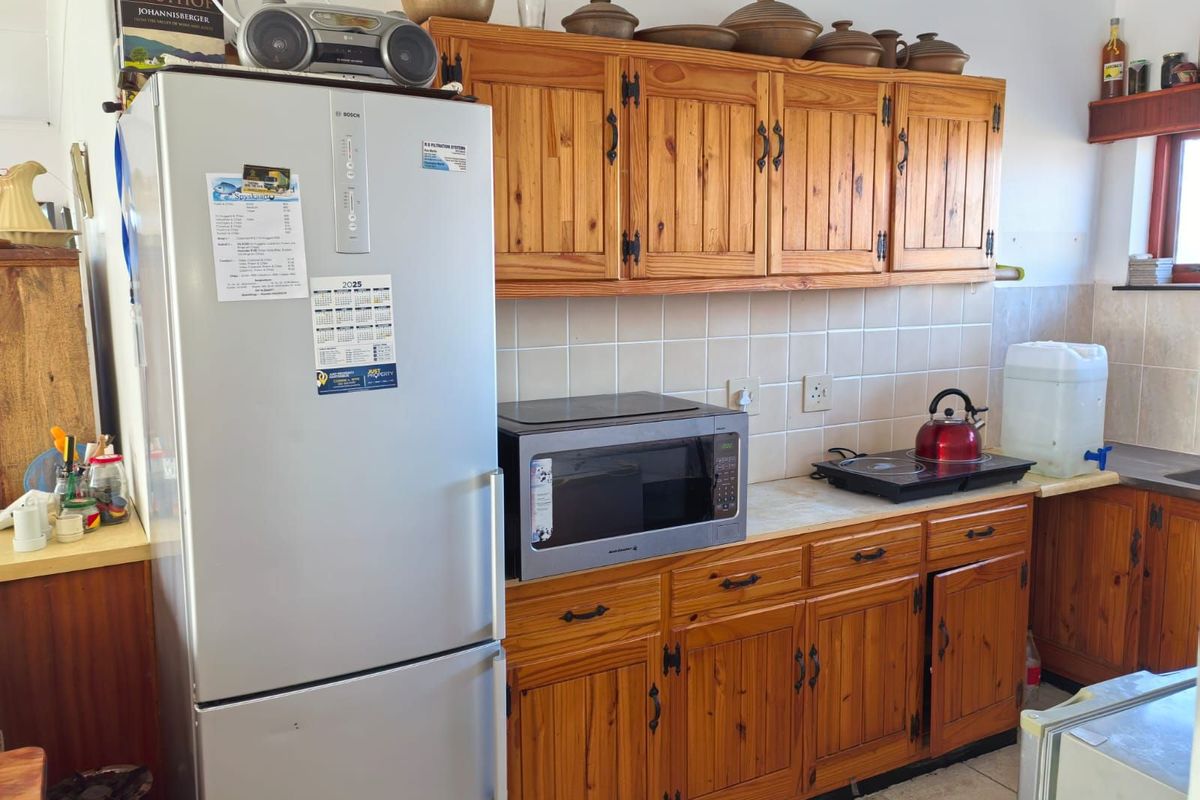 A functional kitchen featuring traditional timber cabinetry, tiled splashbacks, and laminate countertops, providing a classic aesthetic with ample storage space.
