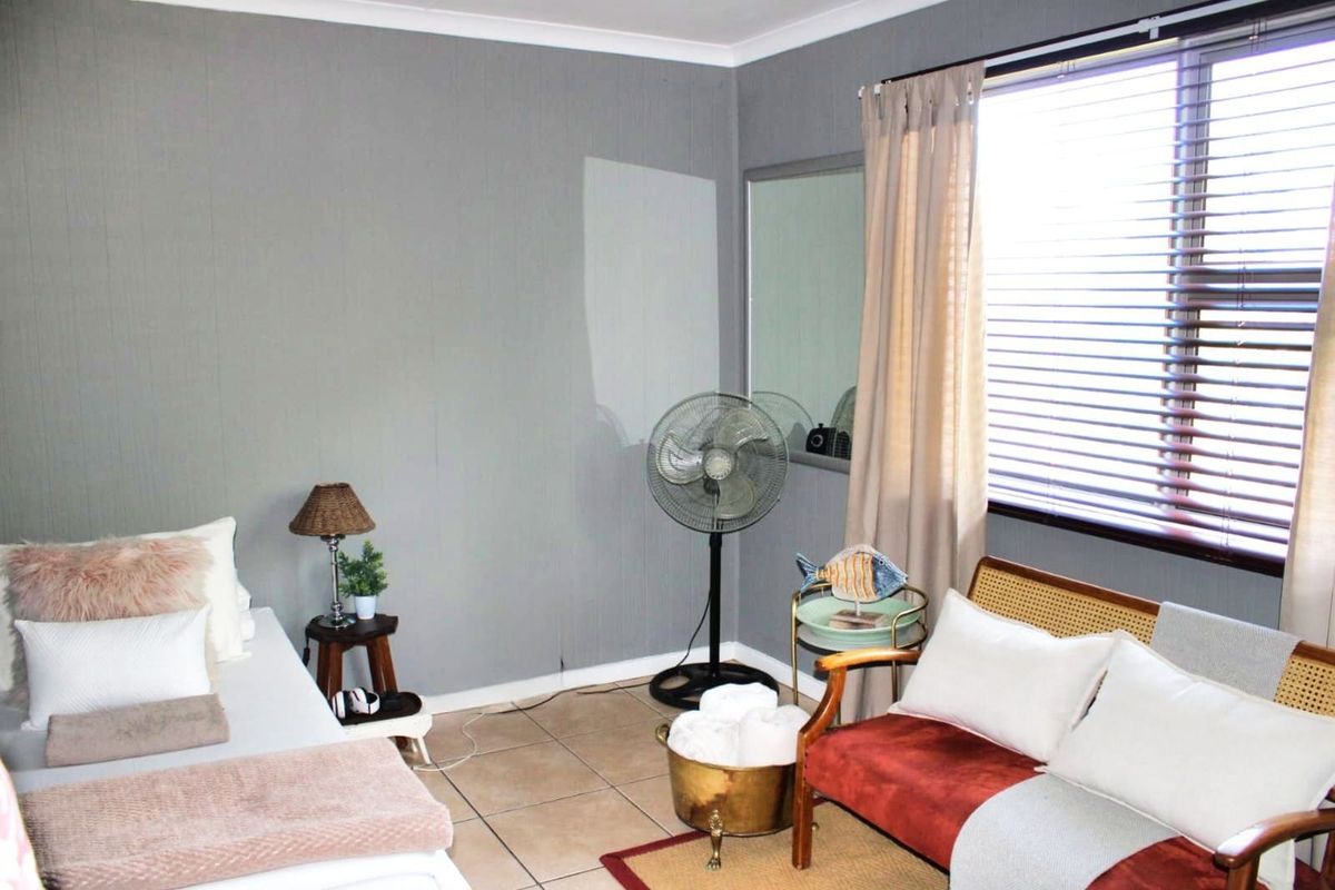 A bedroom featuring tiled flooring, a window with fitted blinds, and neutral wall finishes.