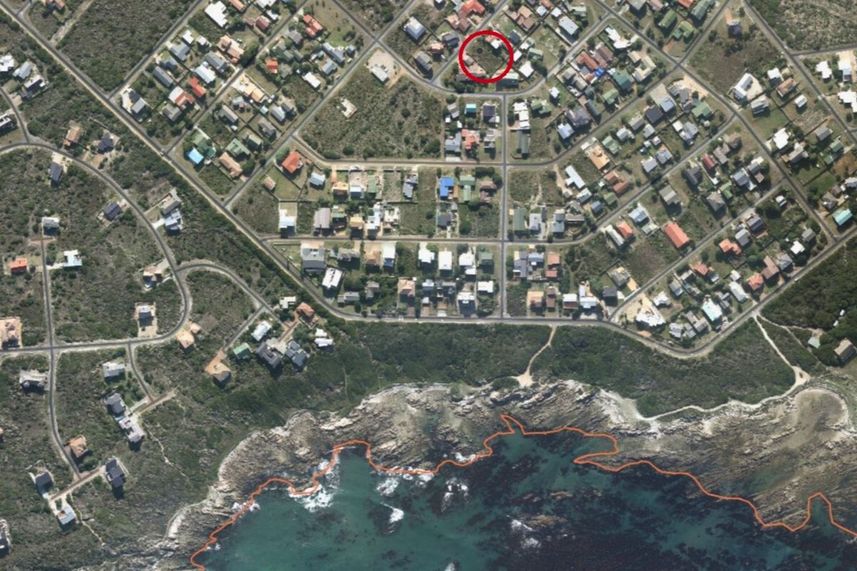 Aerial view of a residential neighborhood showing the location of the vacant land plot highlighted in red.