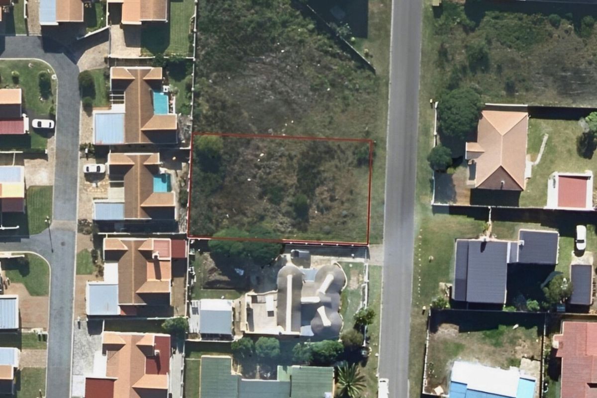 Aerial view of a vacant residential plot situated in a developed suburban neighborhood, ready for new construction.