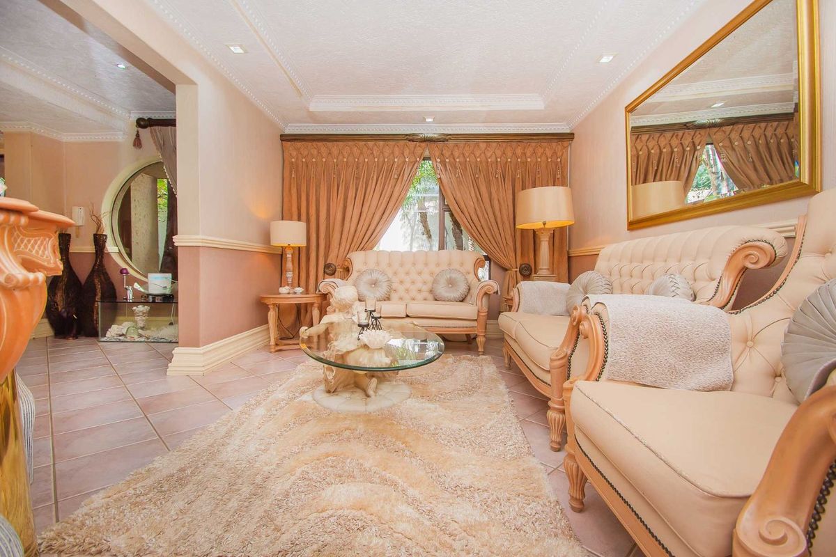 A formal living room featuring tiled flooring, decorative wall molding, recessed ceiling lighting, and a large wall-mounted mirror.