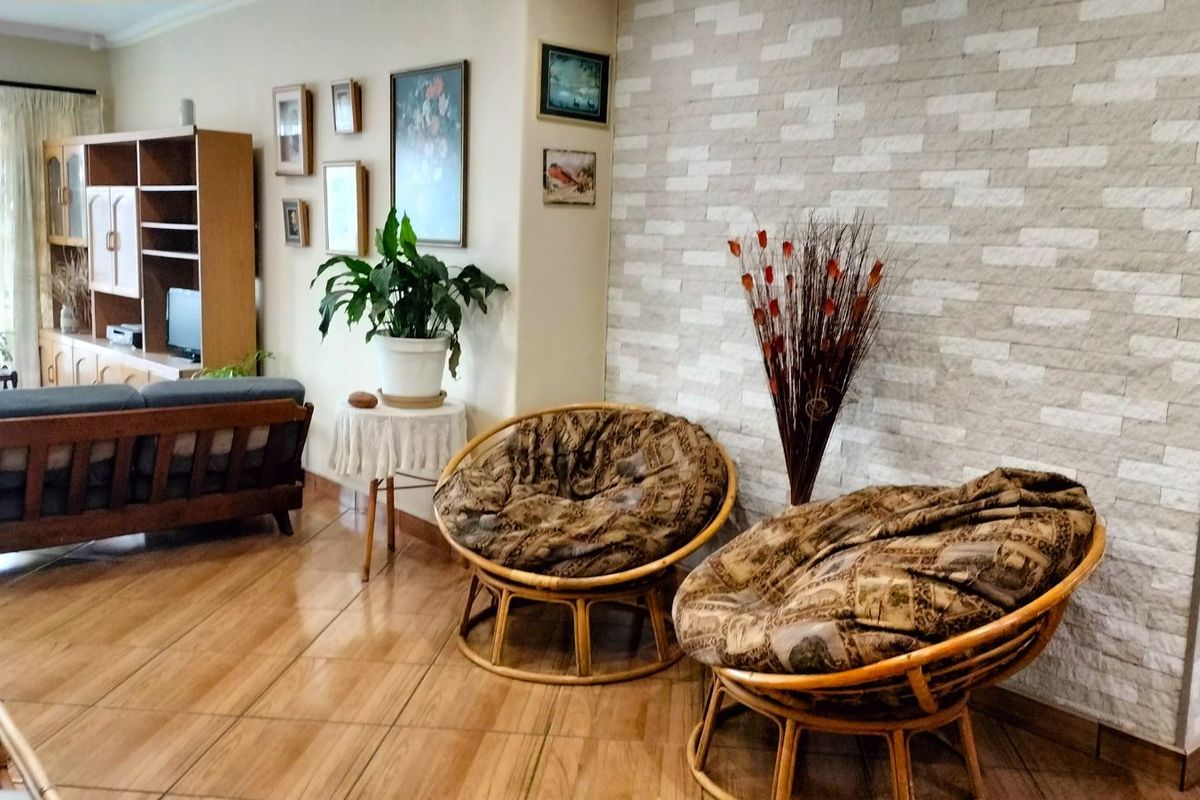A living room featuring tiled flooring and a textured stone feature wall, providing a warm and inviting atmosphere.