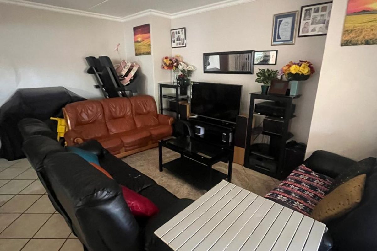 A living room area featuring tiled flooring and crown molding, providing a functional space for relaxation and entertainment.