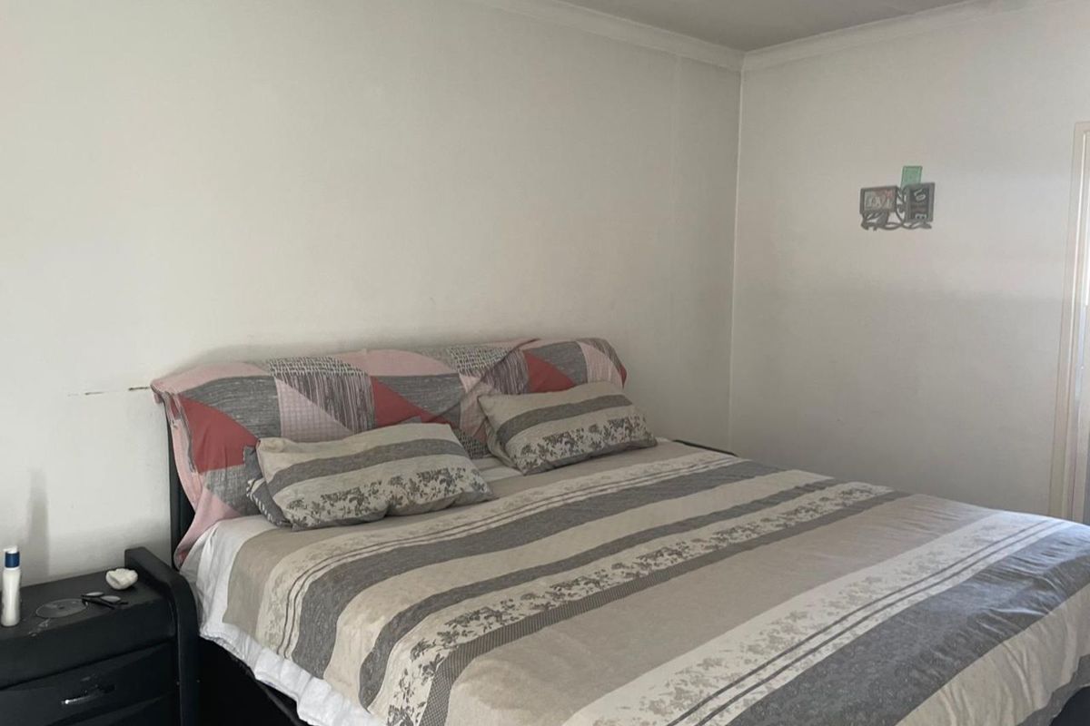 A standard bedroom featuring neutral walls and coved ceiling detailing, providing a functional and simple living space.