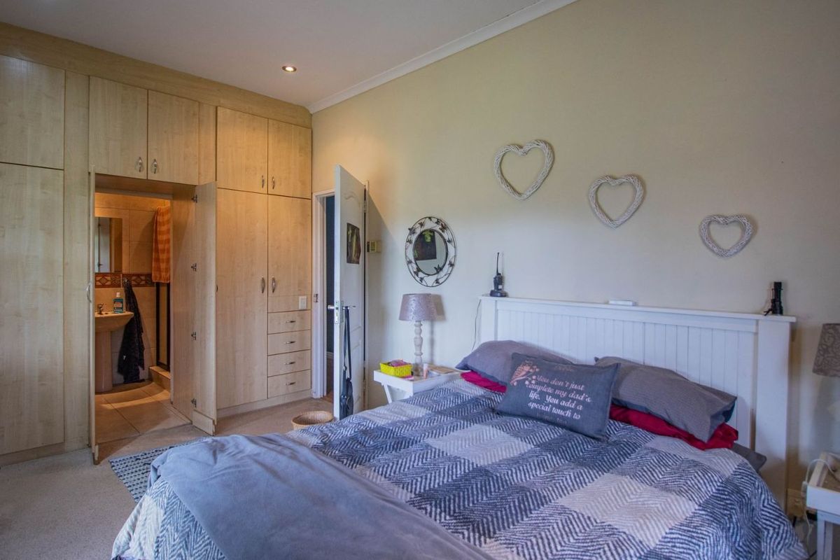 A bedroom featuring extensive built-in wooden cabinetry and an en-suite bathroom access.