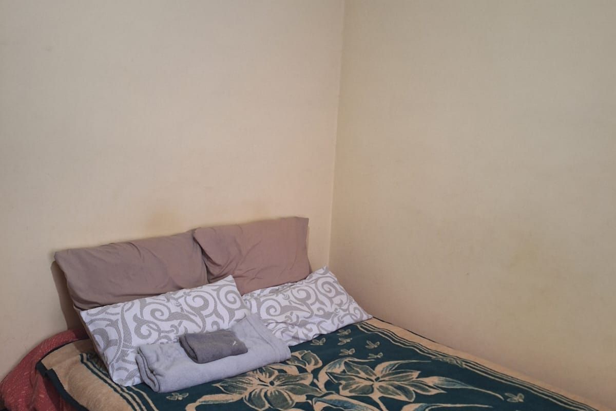 A simple bedroom featuring neutral wall finishes and standard ceiling coving.