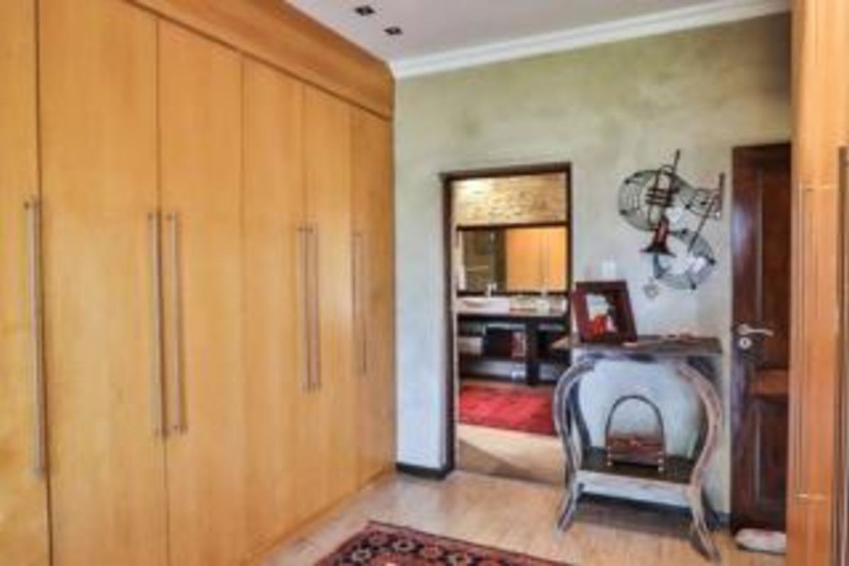 A bedroom featuring extensive built-in wooden cabinetry and direct access to an en-suite bathroom.