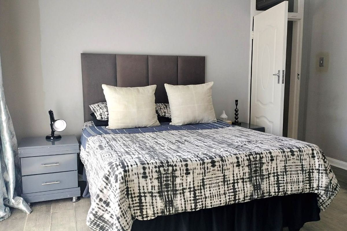 A bedroom featuring tiled flooring, a neutral wall palette, and a built-in door frame.