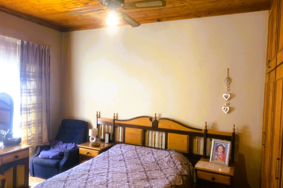 A bedroom featuring a timber-clad ceiling, built-in wooden cabinetry, and a ceiling fan.