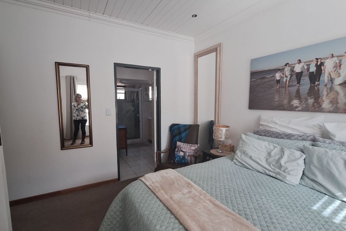 A bedroom featuring a tongue-and-groove ceiling, carpeted flooring, and an en-suite bathroom access.