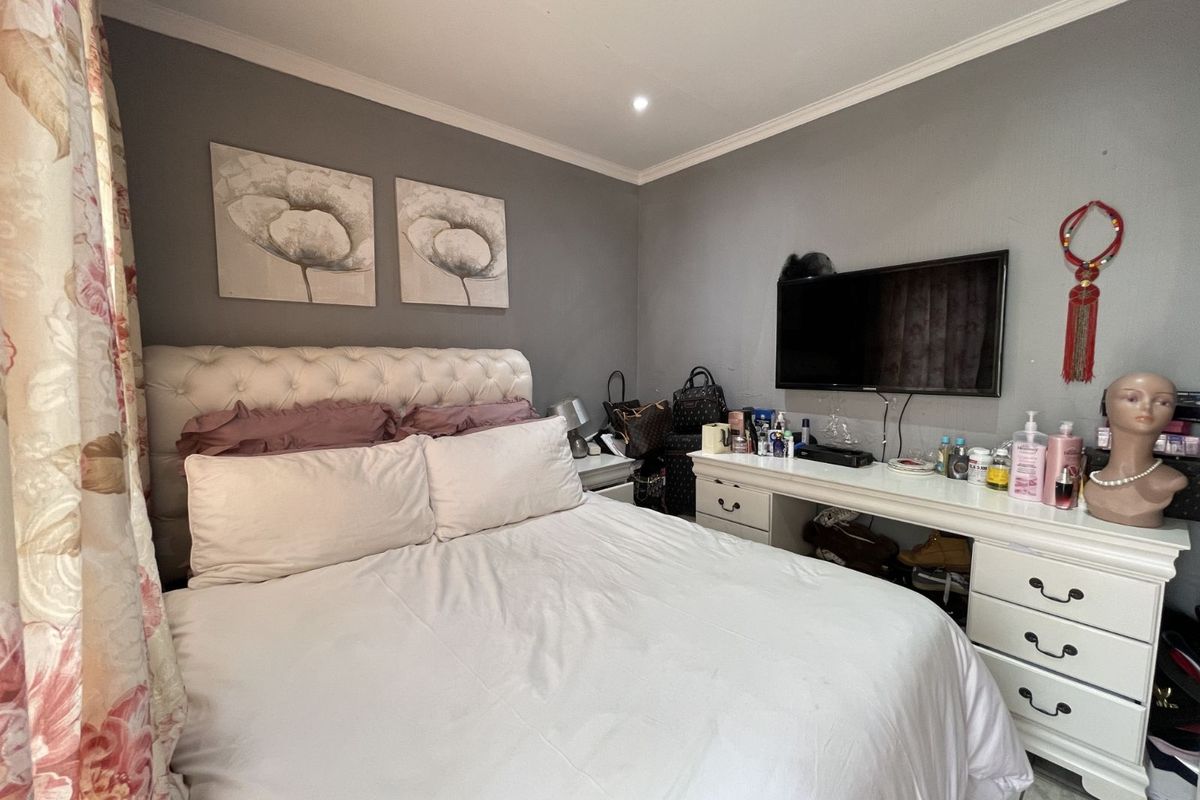 A bedroom featuring grey walls, recessed ceiling lighting, and crown molding, providing a functional space for rest.